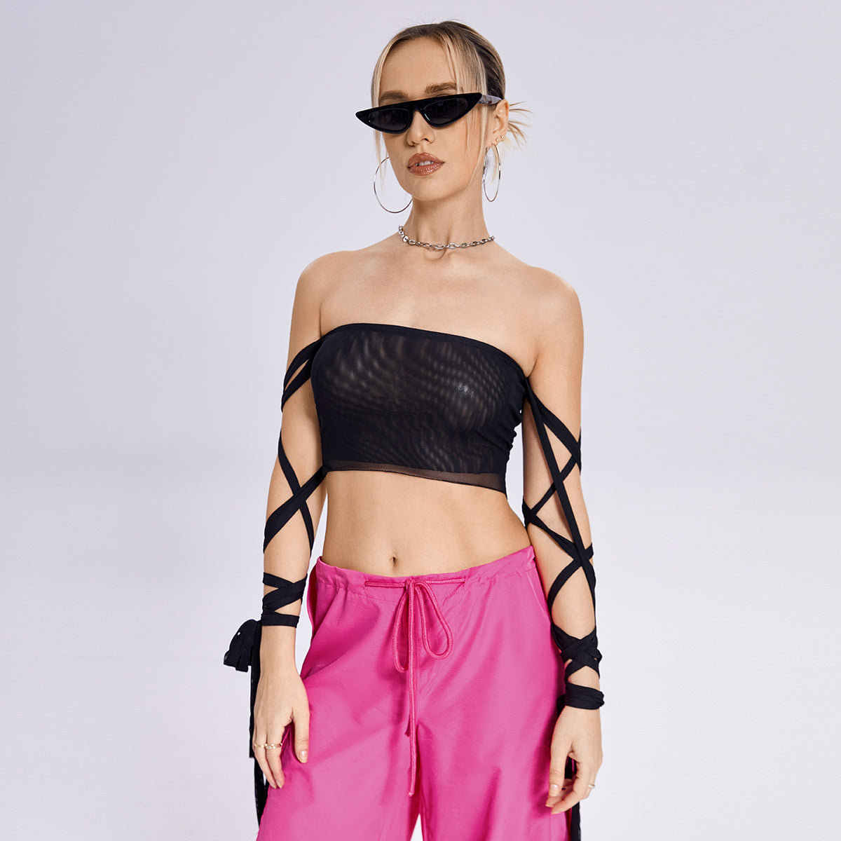 a woman in a black top and pink pants