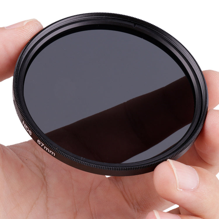 a hand holding a circular black lens