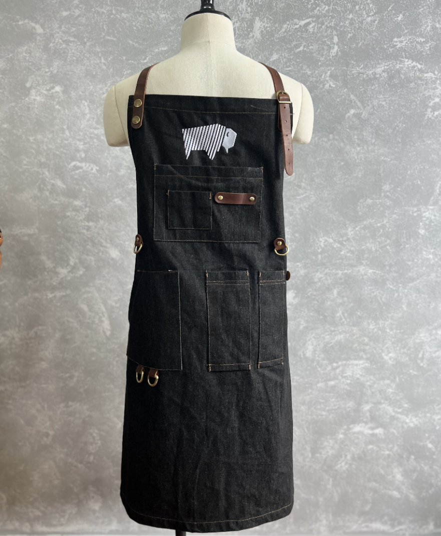 a black apron with brown straps