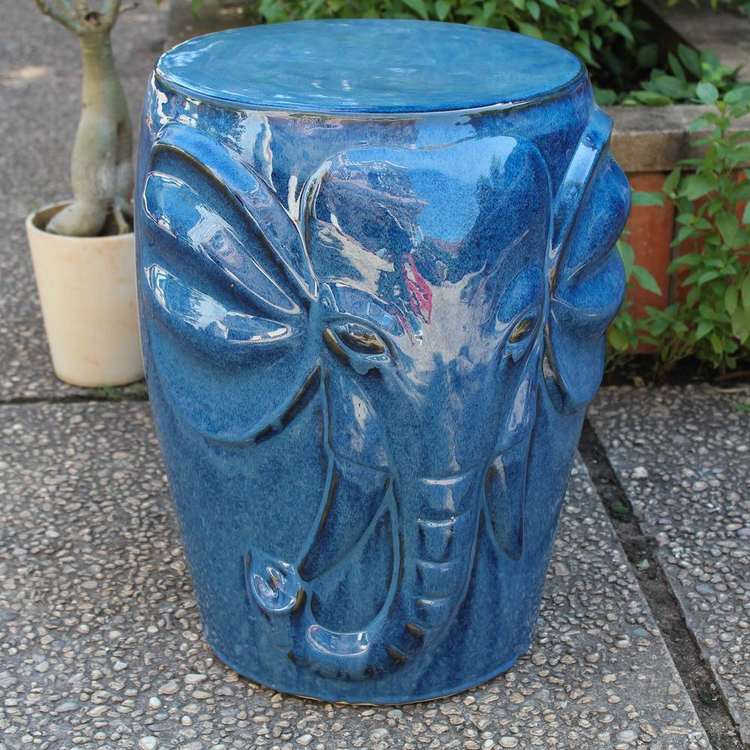 a blue elephant stool on a concrete surface