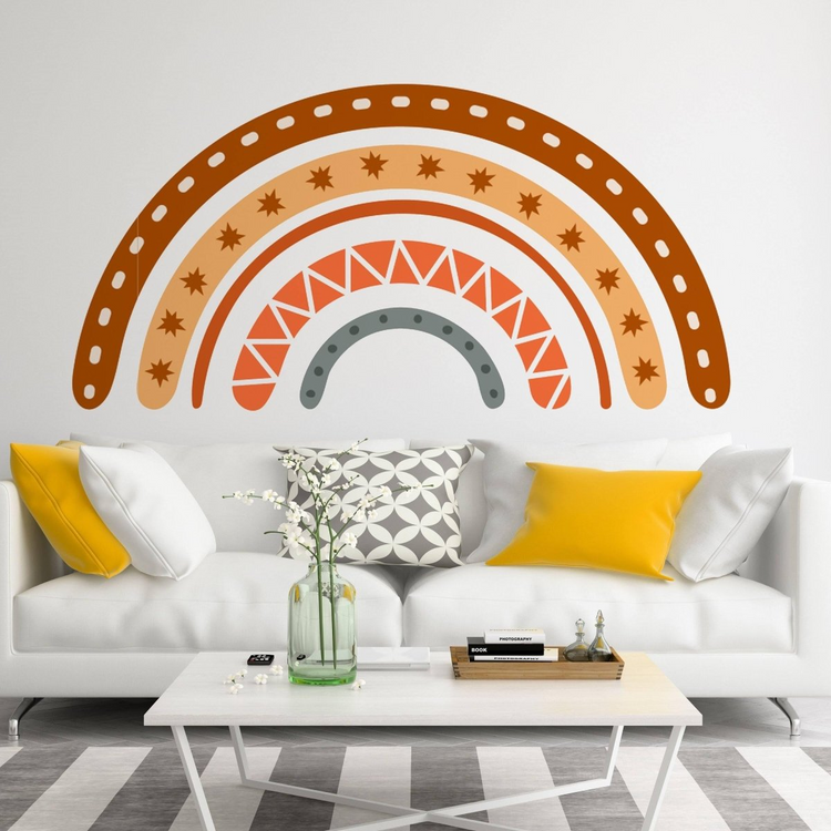 a white couch with yellow pillows and a rainbow on the wall