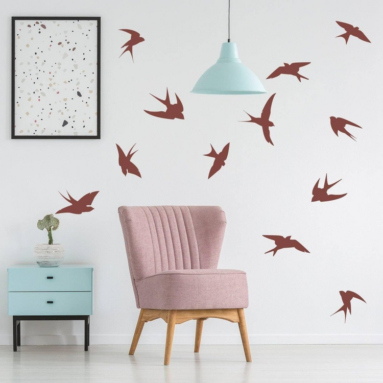 a pink chair in a room with a blue lamp and a picture on the wall
