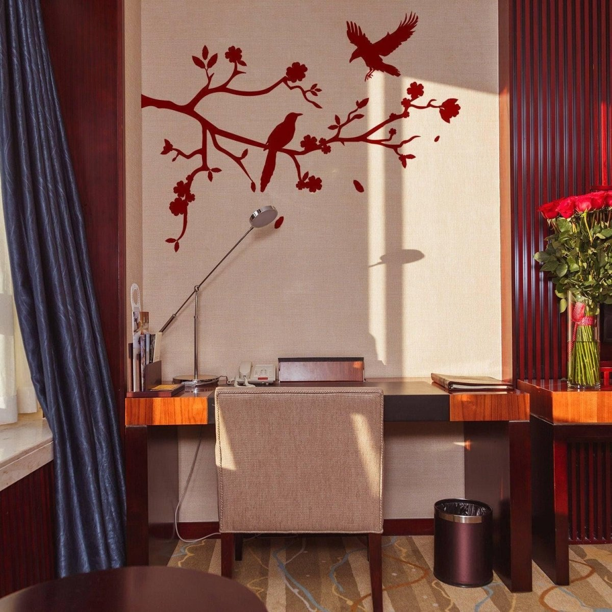a desk with a lamp and a vase of flowers