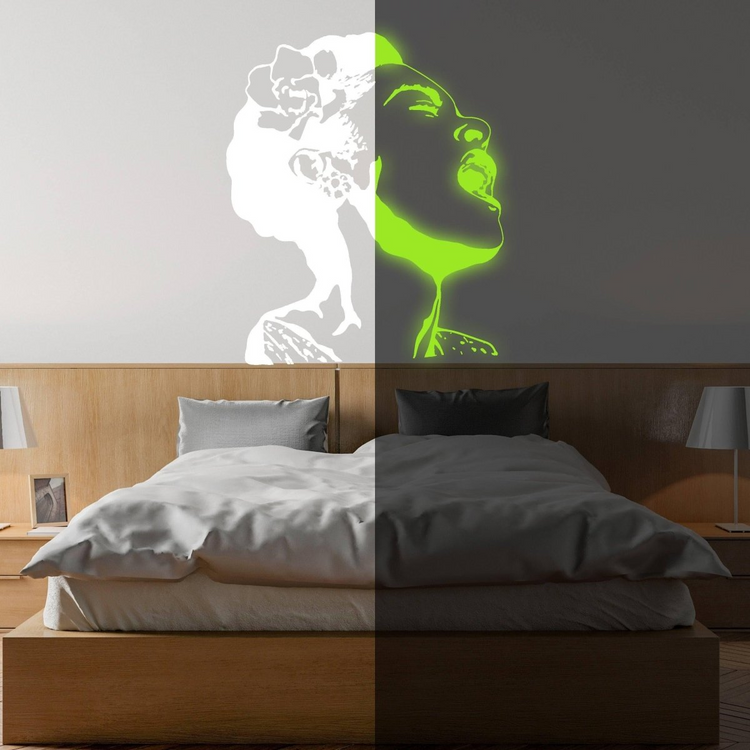 a room with a bed and a picture of a woman