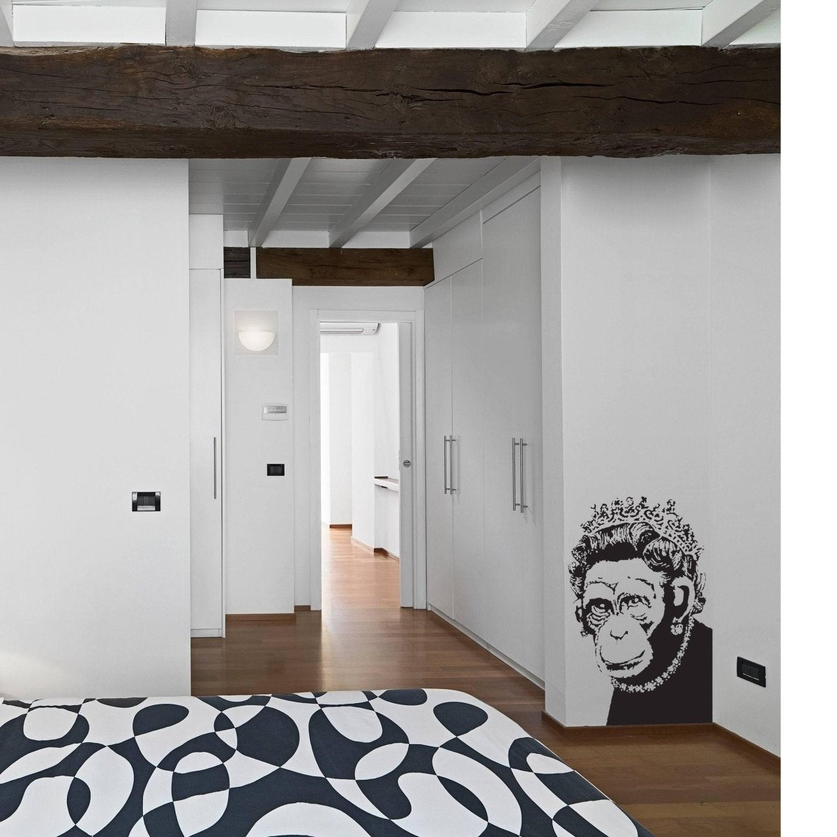 a room with a bed and a wall with a monkey face on it
