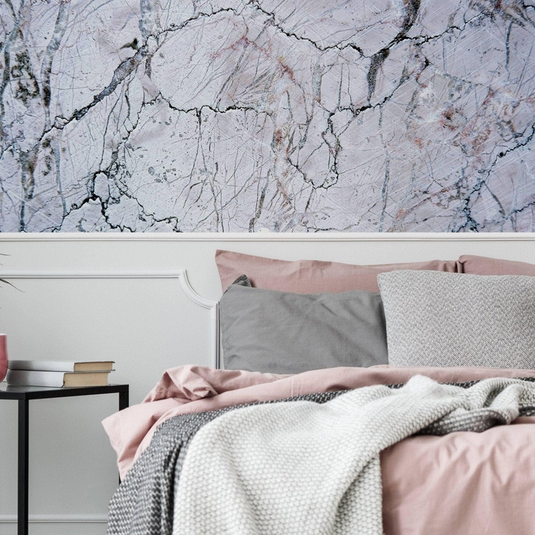 a bed with pink and grey pillows
