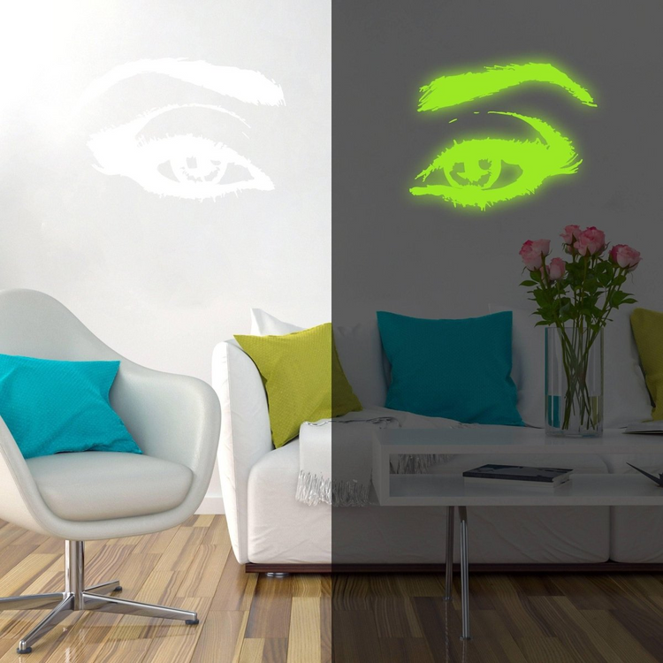 a room with a white couch and a white table with a green and blue pillow