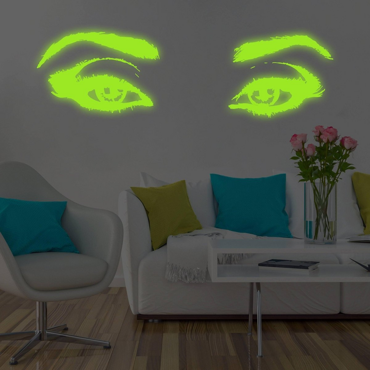 a room with a couch and a vase of flowers and a white table with a white couch and a white coffee table with a vase of flowers and a white table with a green and blue pillow and