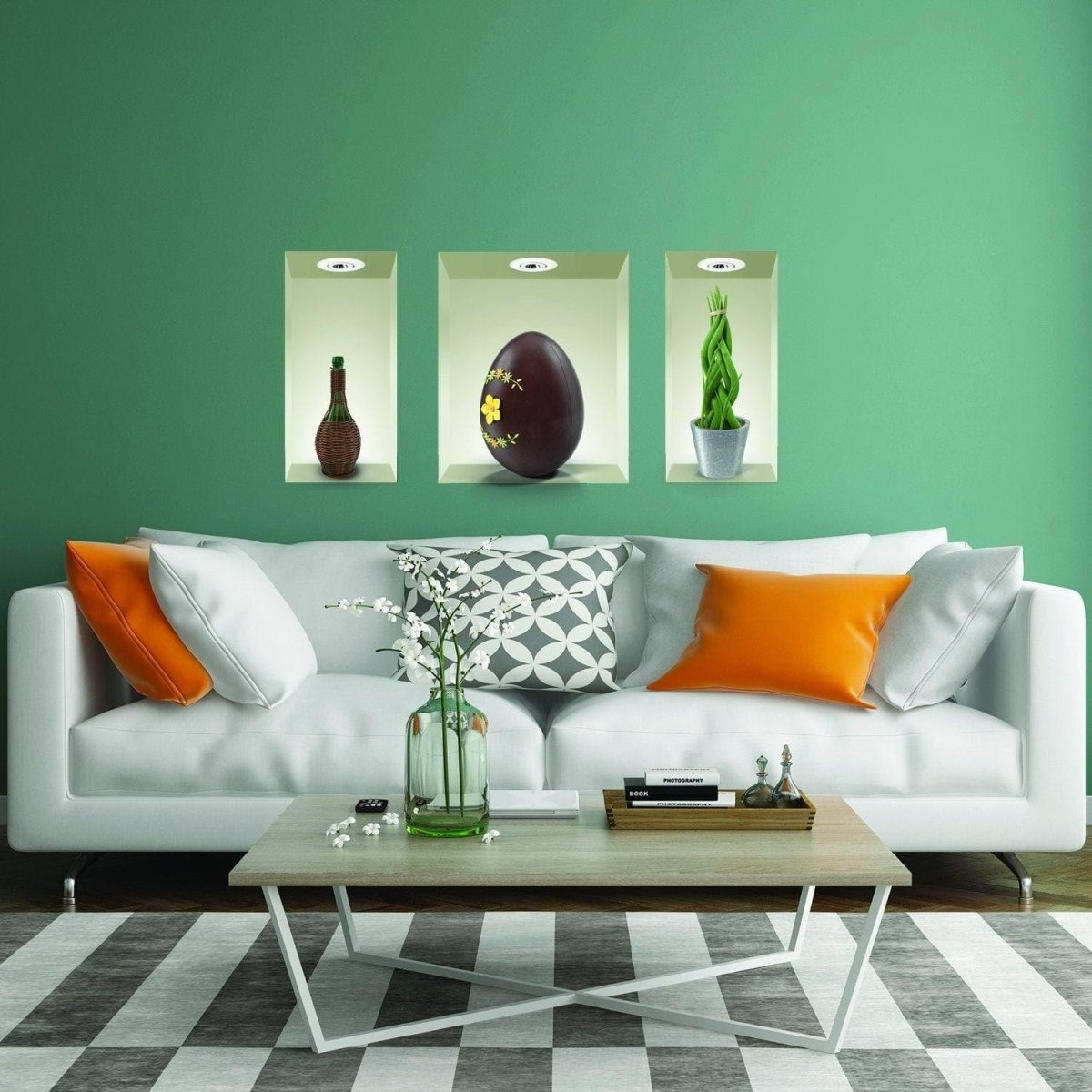 a white couch with orange pillows and a coffee table with a vase of flowers on it