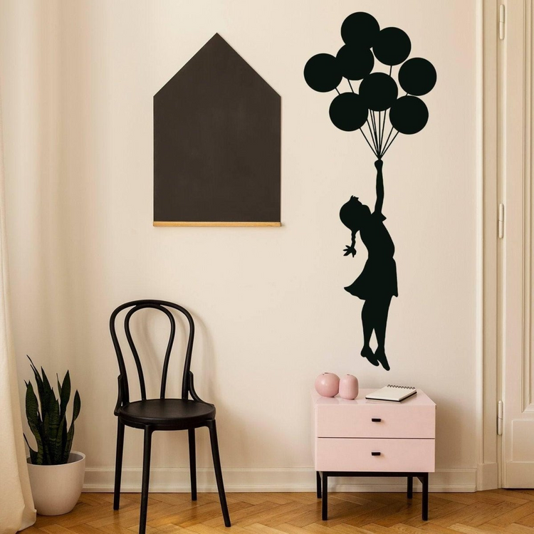 a girl holding balloons on a wall