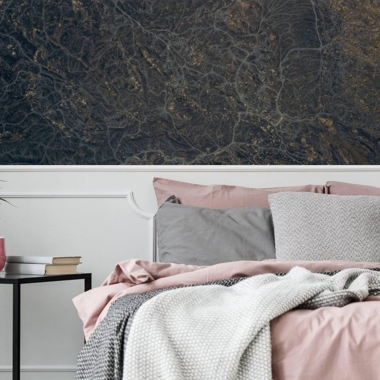 a bed with pink and grey pillows and a table with books