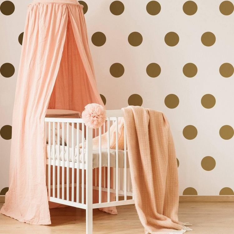 a crib with a canopy and a blanket in a room with polka dots