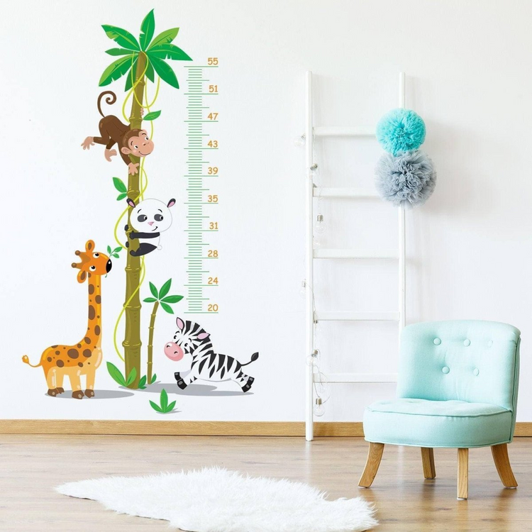 a wall decal with animals and a chair in a room