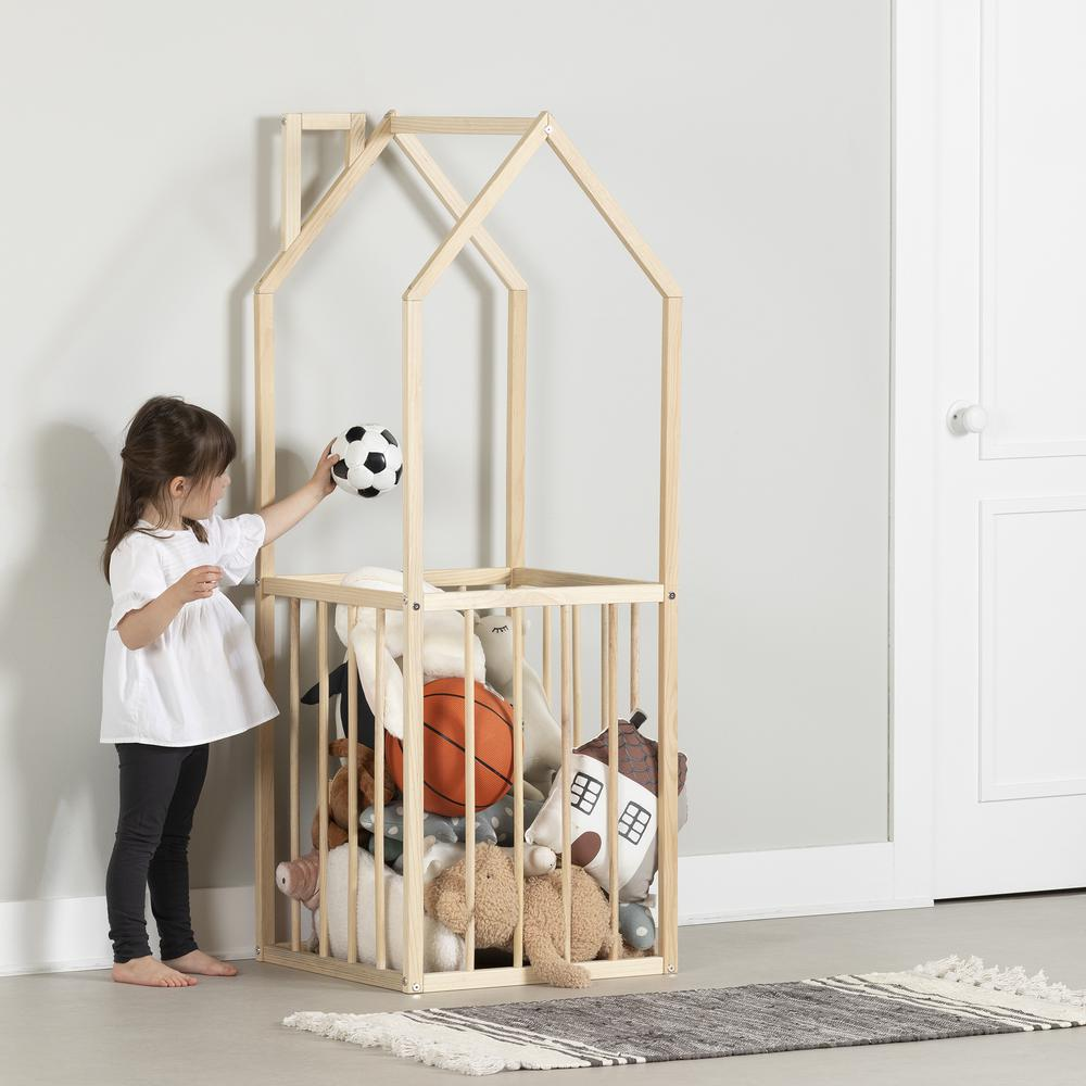 a girl holding a ball in a wooden cage