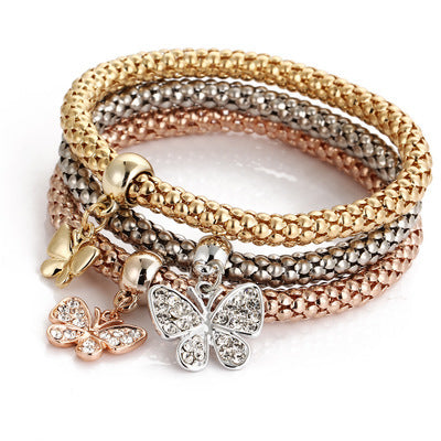 a stack of bracelets with a butterfly charm