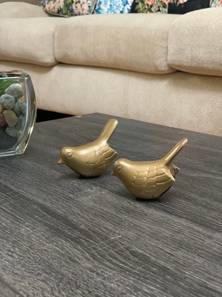 two gold birds on a table