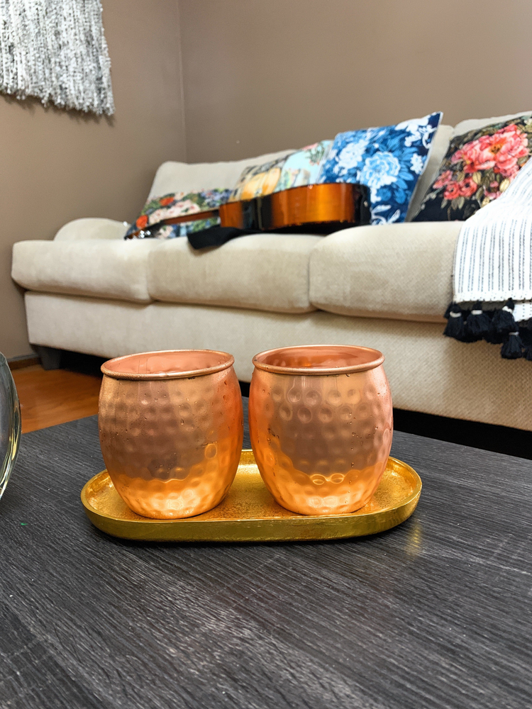 a coffee table with two copper cups on it