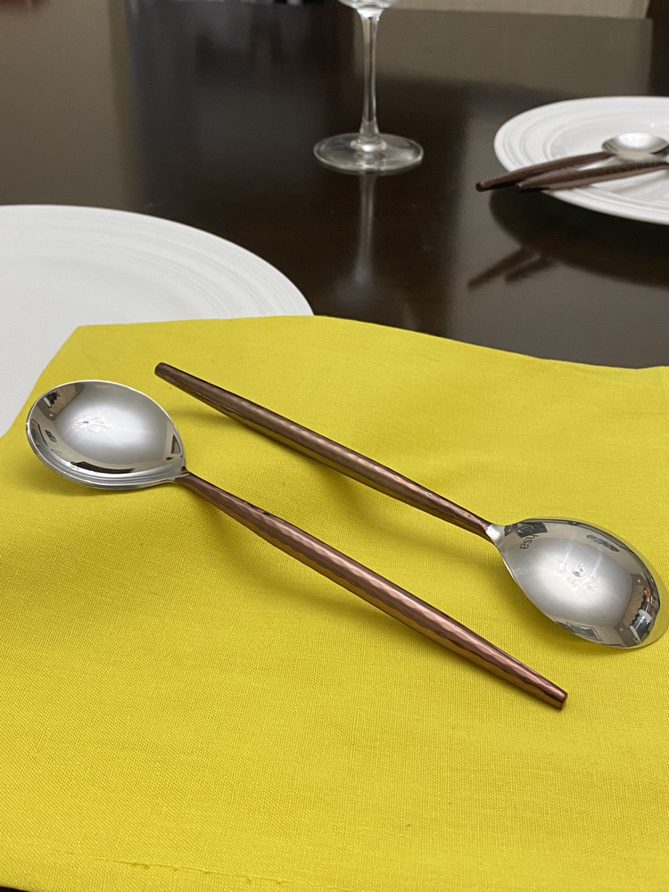 a pair of spoons on a yellow napkin