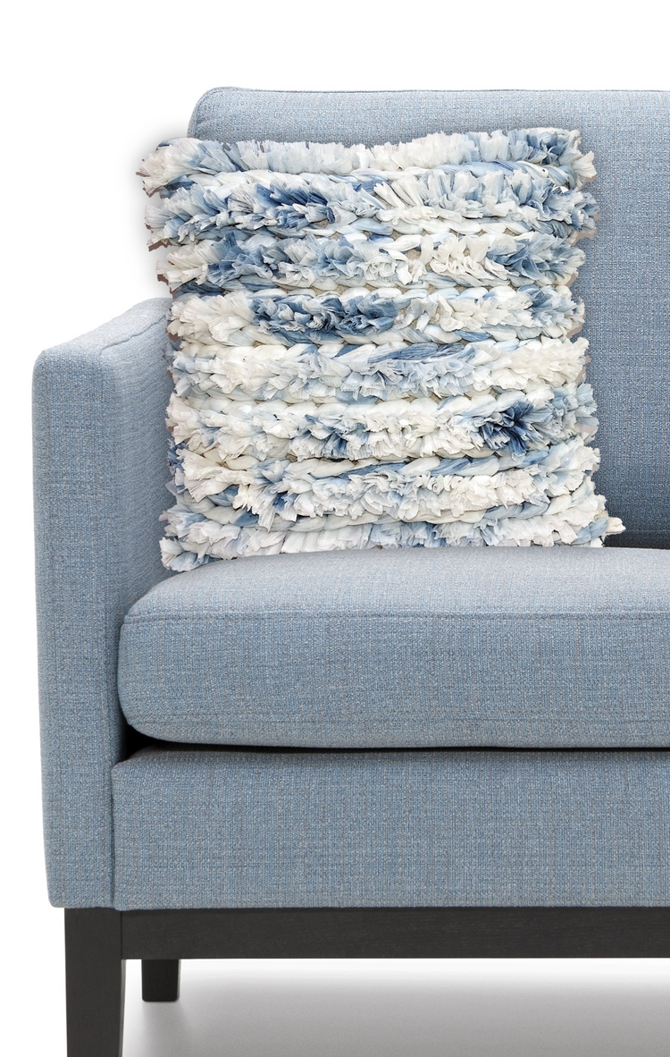 a blue and white pillow on a couch