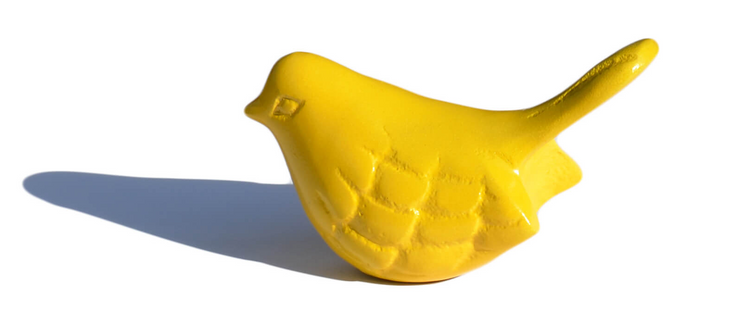 a yellow bird statue on a white background