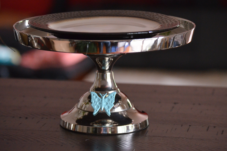 a silver plate with a blue butterfly decoration on it