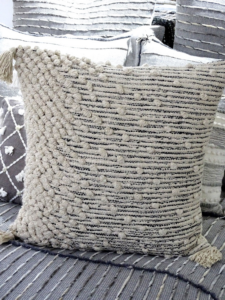 a white pillow with tassels on it