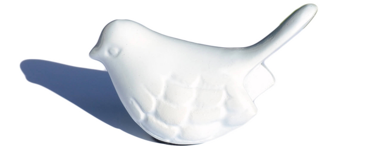 a white ceramic bird on a white background
