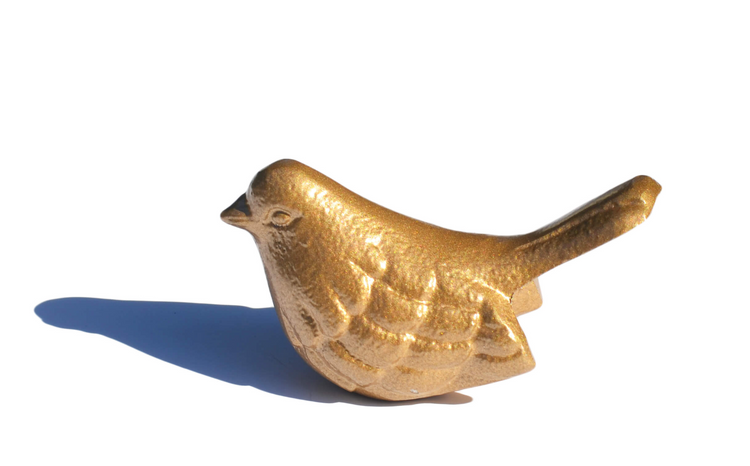 a gold bird statue on a white background