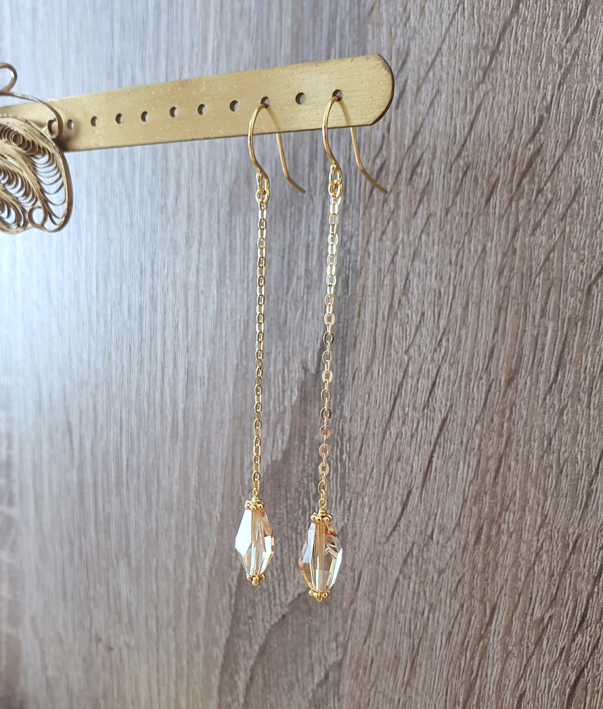 a pair of gold earrings from a stick