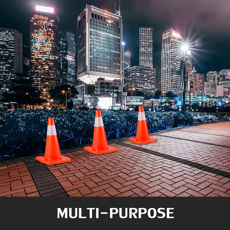 a group of orange cones on a brick path with a city in the background