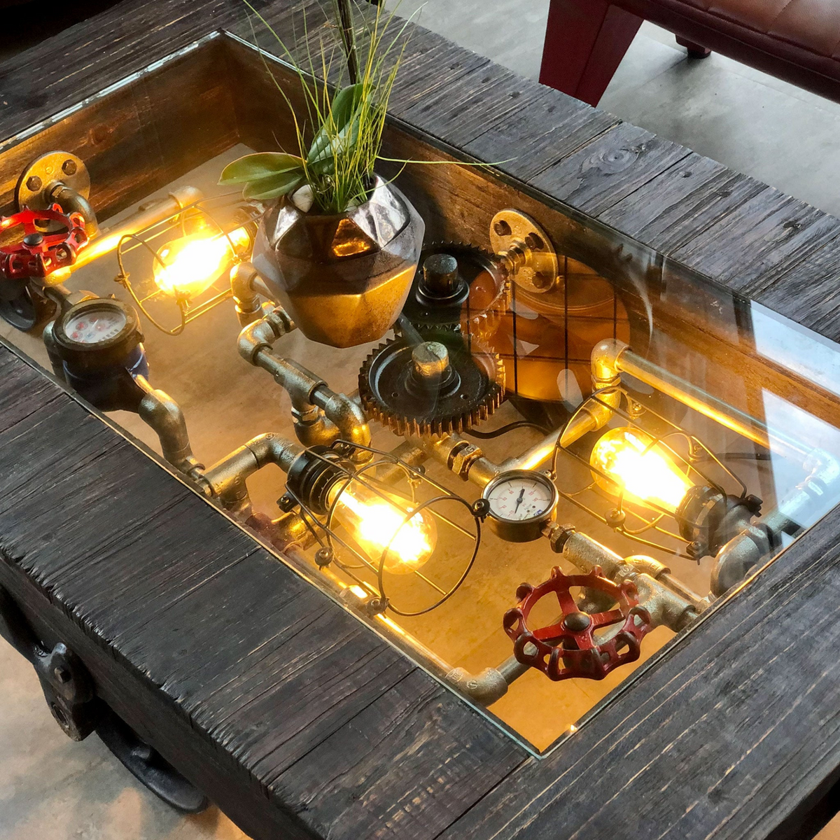 a table with a glass top and a plant in it