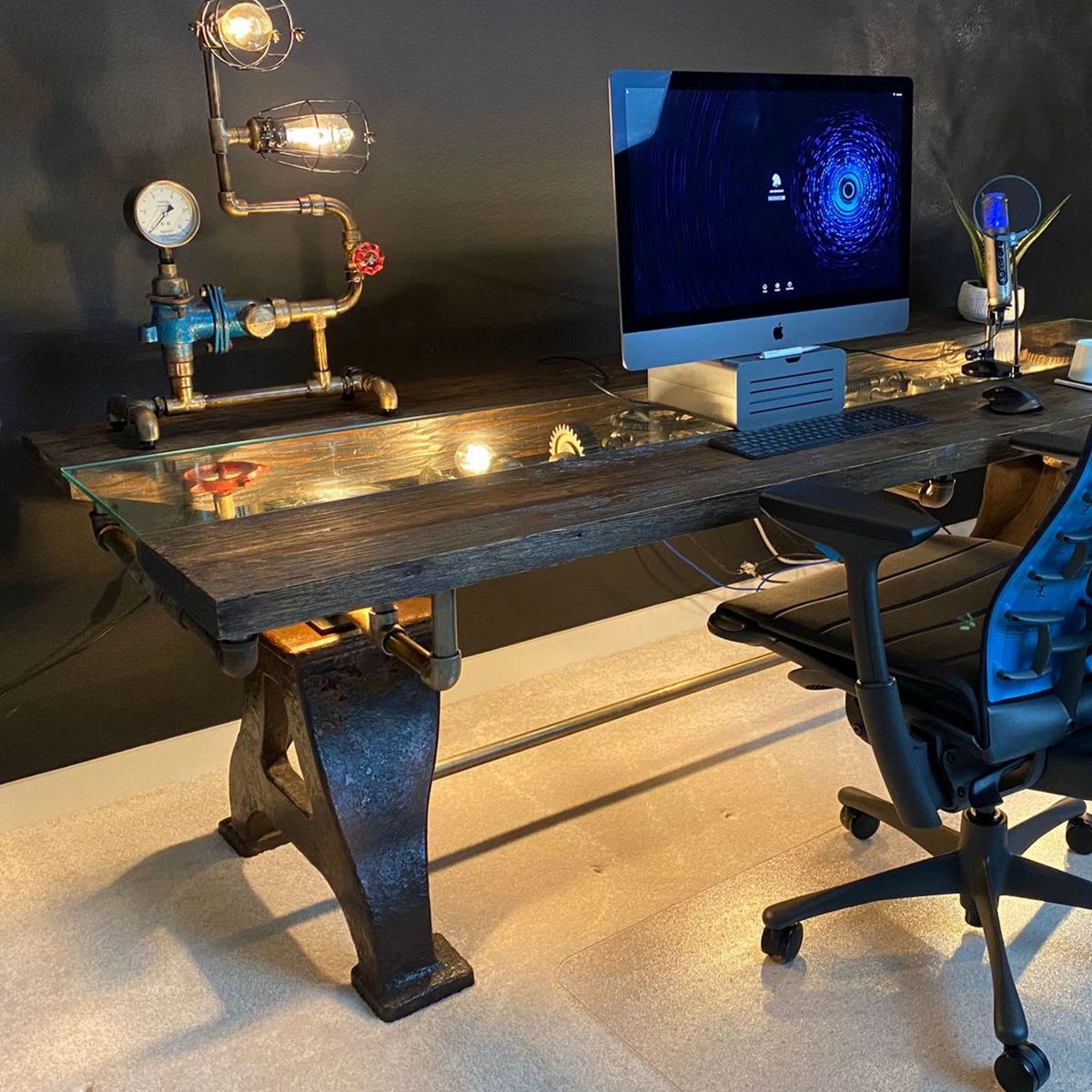 a desk with a computer and a lamp