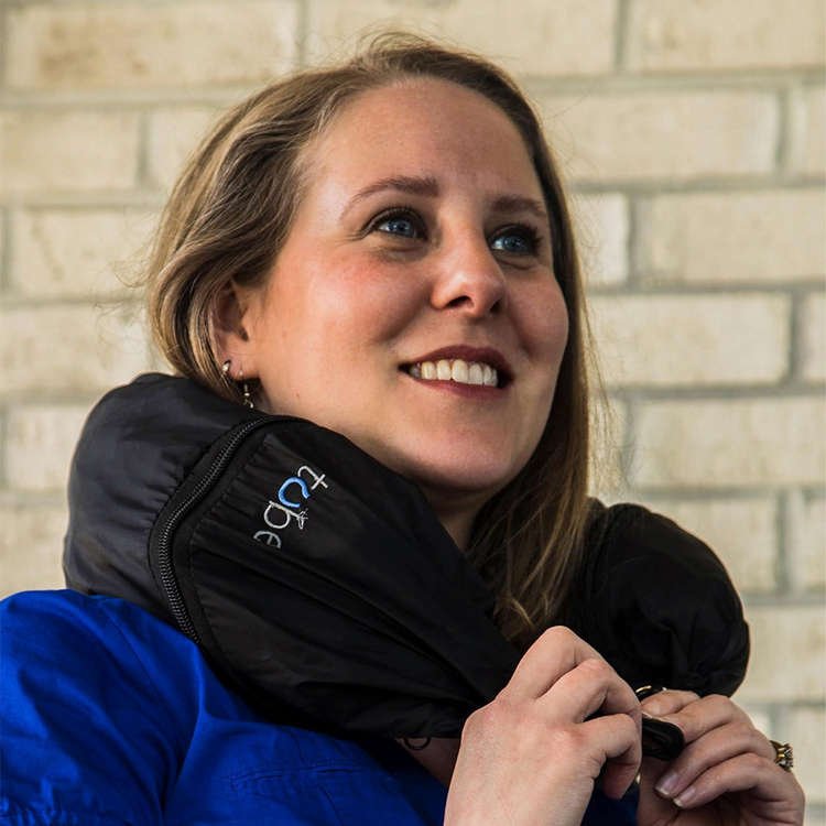 a woman smiling with a black bag on her shoulder