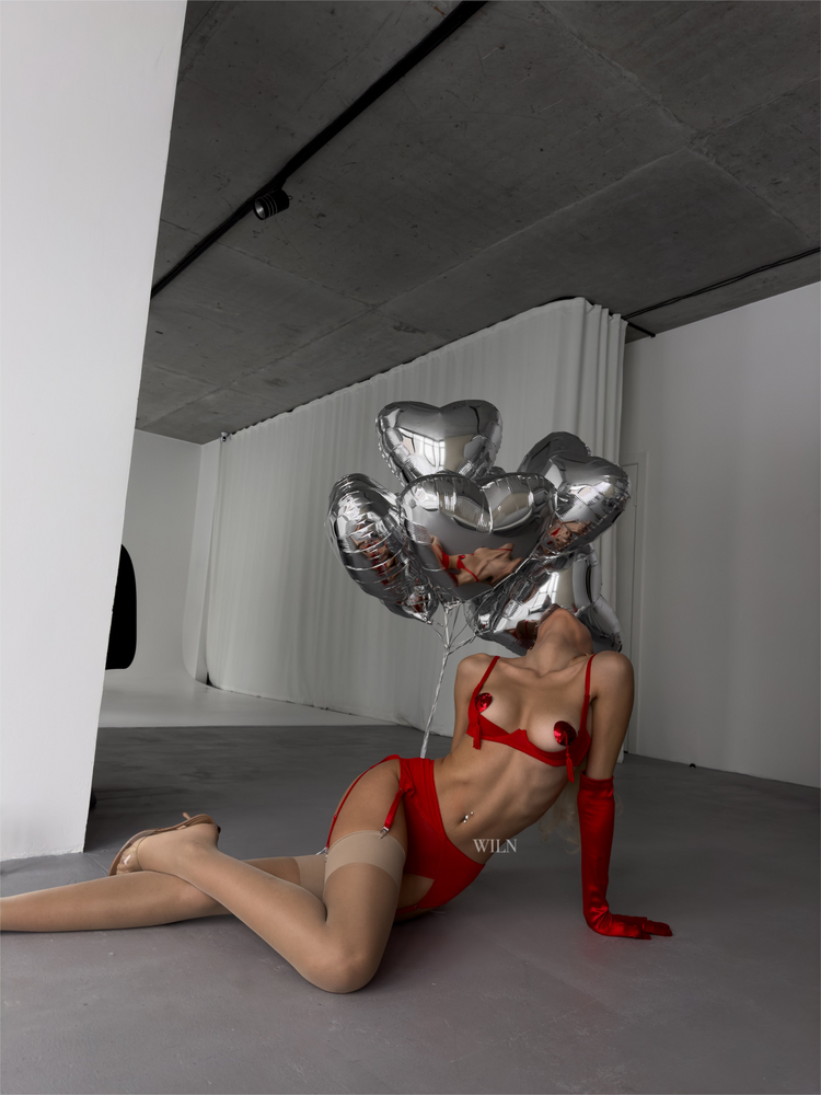 a woman lying on the floor with a silver balloon