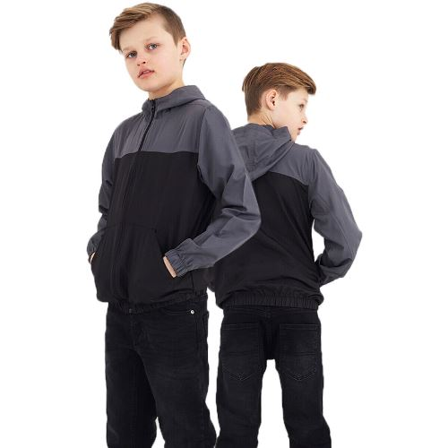 a boy standing back to back with his hands in his pockets