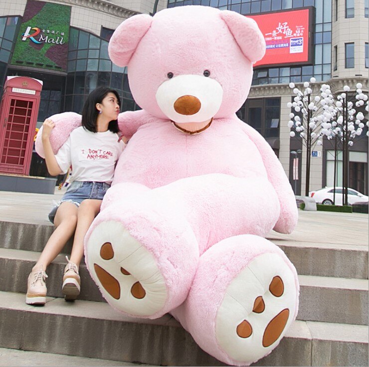 a woman sitting on steps with a large stuffed teddy bear