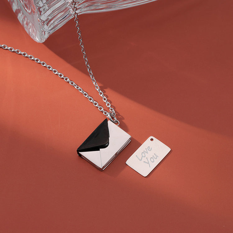 a silver and black envelope necklace with a silver chain and a silver tag on a chain