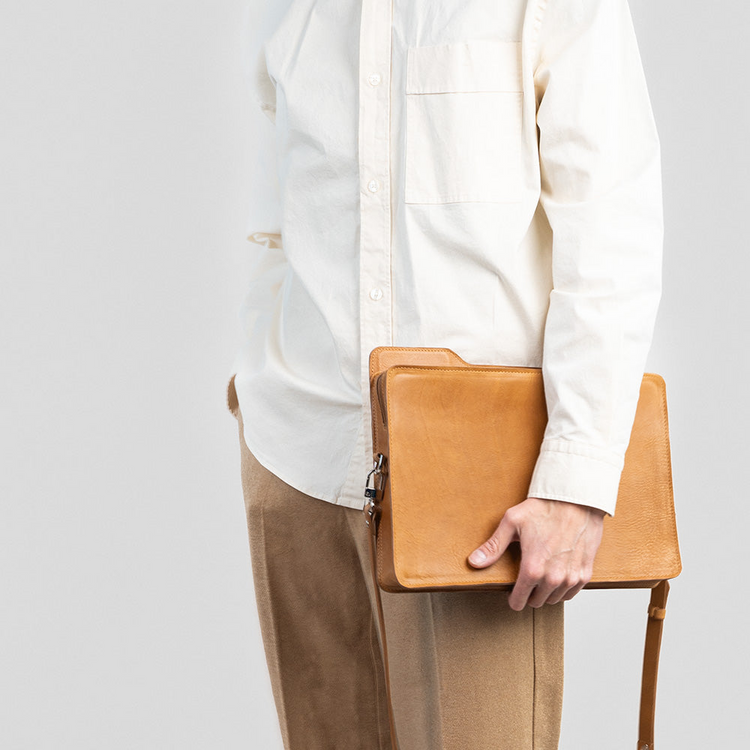 a person holding a leather bag