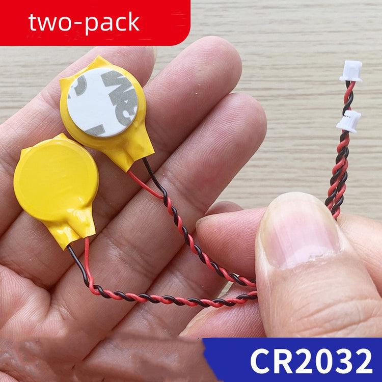 a hand holding a pair of small yellow and black wires