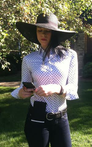 a woman in a hat looking at a phone