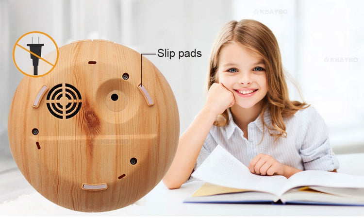 a girl sitting at a table with a book and a circular object