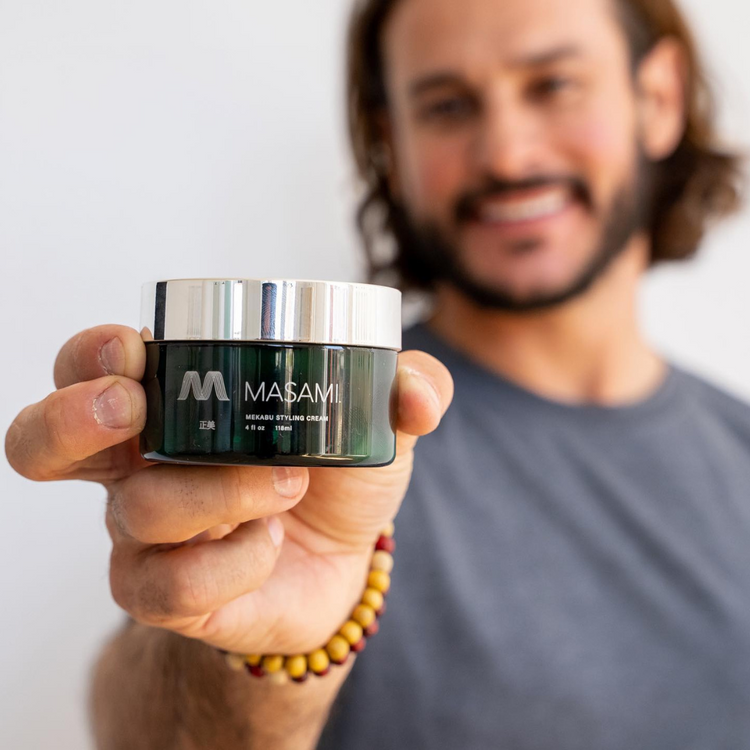 a man holding a small jar of cream