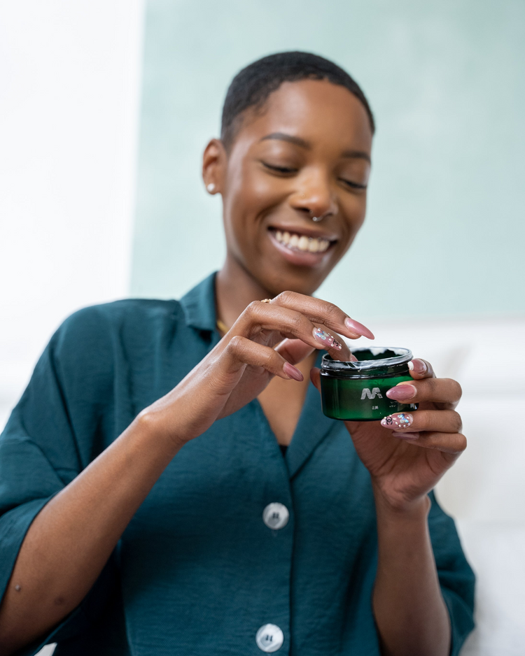 a woman holding a jar of cream