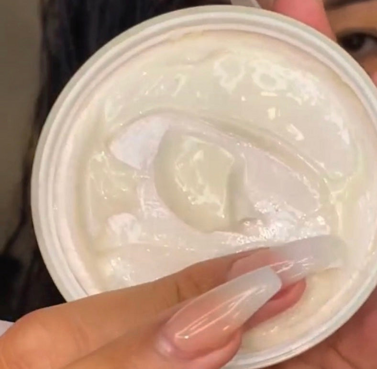 a person holding a jar of white gel