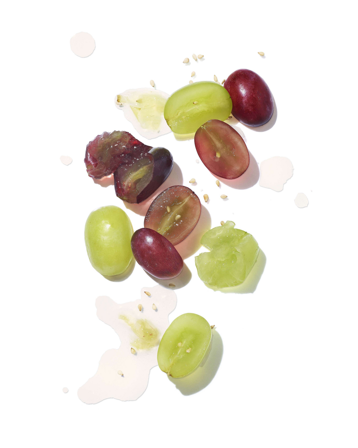 a group of grapes on a white surface