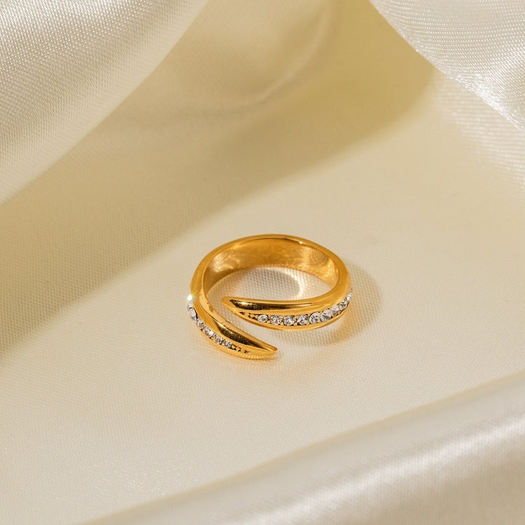 a gold ring with diamonds on a white fabric