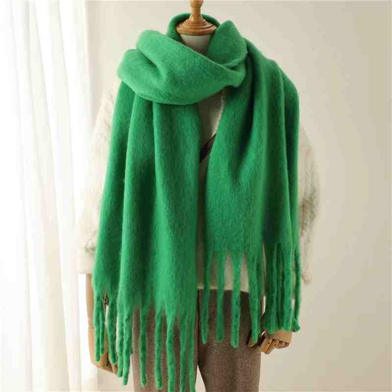 a green scarf on a mannequin