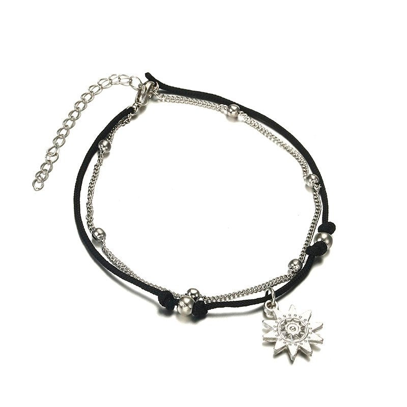 a black and silver bracelet with a silver sun charm