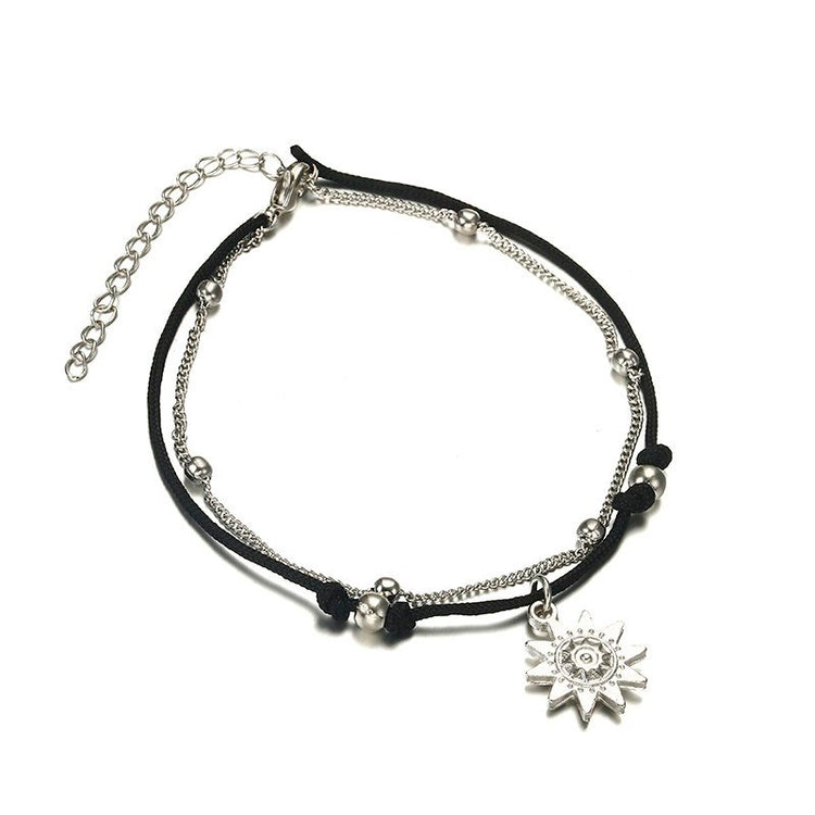 a black and silver bracelet with a silver sun charm