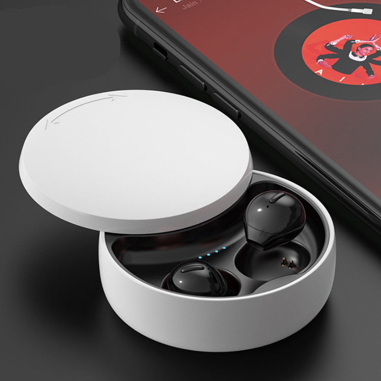 a white box with black earbuds in it next to a cellphone